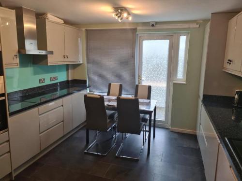 uma cozinha com mesa e cadeiras e uma janela em Luxury House, 4 bedrooms fully furnished em North Woolwich