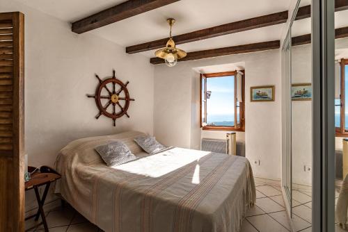 a bedroom with a bed with a clock on the wall at Pentone in Cervione