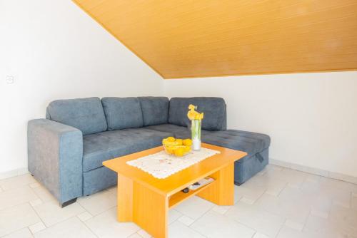 a living room with a blue couch and a table at Marva stylish Mediterranean accomodation with beautiful view in Zubovići