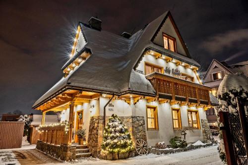 a house with a christmas tree in front of it at Willa Mały Dworek in Zakopane