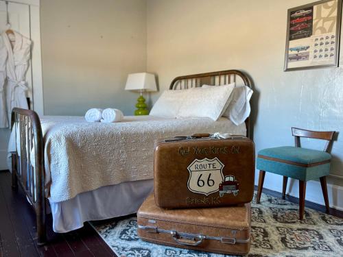 a bedroom with a bed with a suitcase and a chair at The Old Riverton Post B&B in Riverton