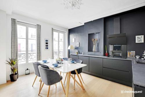 une cuisine avec une table et des chaises dans une pièce dans l'établissement Elegant apartment - 1BR-4P - Les Batignolles, à Paris