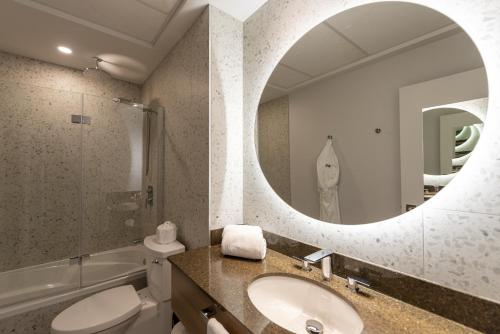a bathroom with a sink and a mirror at Hotel Royal William, an Ascend Collection Hotel in Quebec City