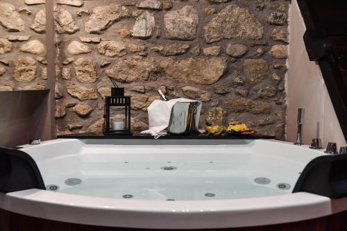 a bath tub in a room with a stone wall at Vicolo72 in Calitri