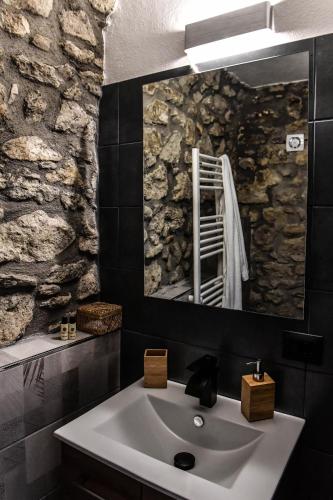 a bathroom with a sink and a stone wall at Vicolo72 in Calitri