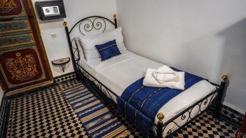 a small bedroom with a bed with a white towel at Riad Green House in Fès
