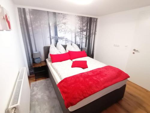 a bedroom with a large bed with red and white pillows at Ferienwohnung Berg(Aus)zeit Ennstal in Öblarn