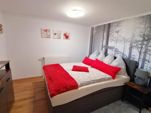 a bedroom with a bed with red and white pillows at Ferienwohnung Berg(Aus)zeit Ennstal in Öblarn