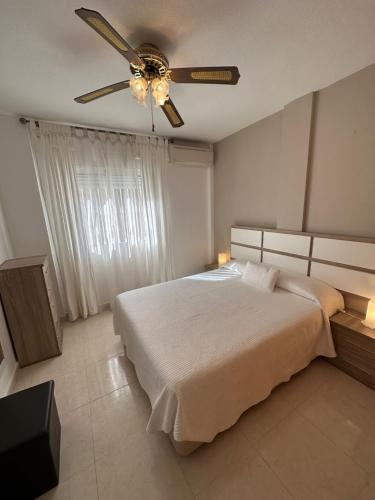 a bedroom with a bed and a ceiling fan at Agradable casa con piscina in Bolnuevo