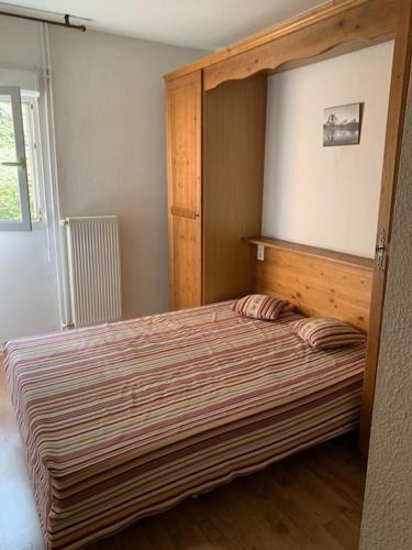 - une chambre avec un grand lit et un cadre en bois dans l'établissement T3 idéal ski et randonnée en famille, à Cauterets