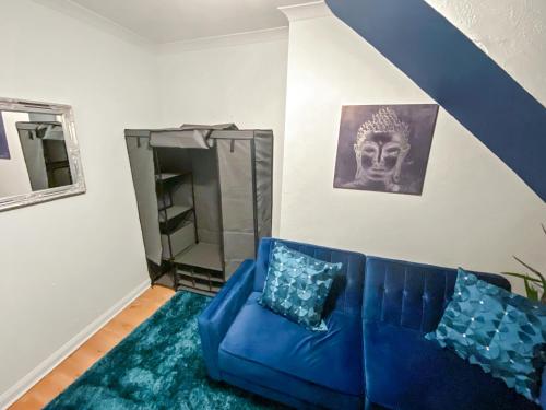 a living room with a blue couch and a mirror at 2 Bed Central Hub in Medway in Chatham