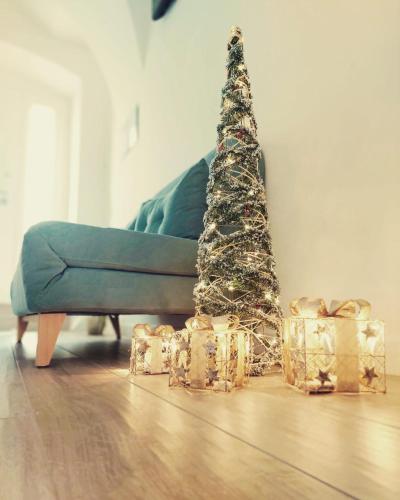 a christmas tree and presents in front of a couch at 1820 Marè in Molfetta