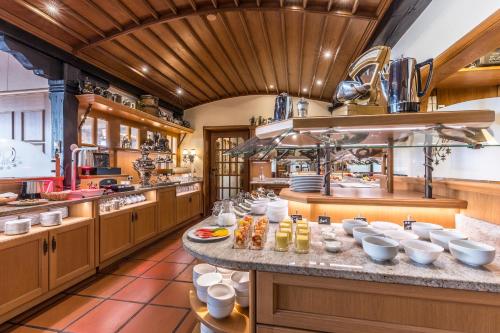 a large kitchen with a large counter with dishes on it at Wellness Privathotel Post an der Therme in Badenweiler