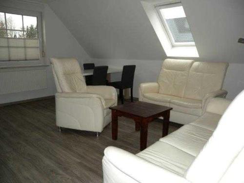 a living room with white furniture and a table at Trassenheide Strandgalopp am Walde Wohnung W1TE in Trassenheide