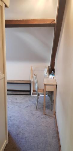 a room with a desk and a chair and a table at Hôtel Terminus in Luz-Saint-Sauveur