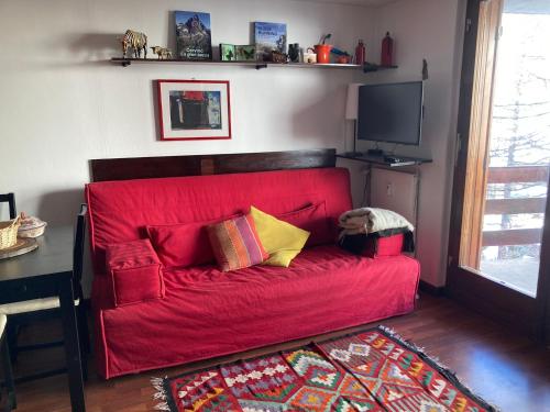 a child laying on a red couch in a living room at Appartamento + box a Cervinia con vista in Breuil-Cervinia