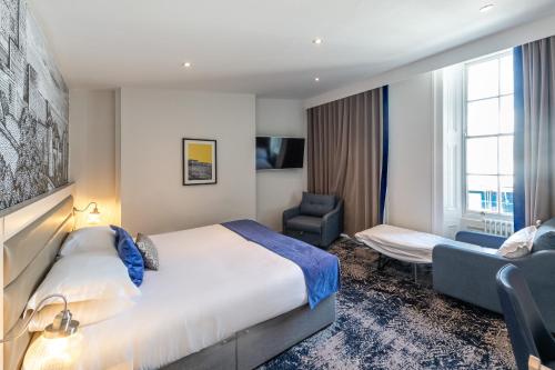a hotel room with a bed and a chair at Dover Marina Hotel & Spa, Tapestry Collection by Hilton in Dover