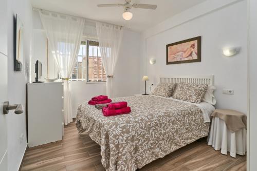 een slaapkamer met een bed met rode kussens erop bij Apartamento Amador in Algarrobo-Costa