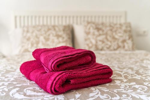 een roze handdoek bovenop een bed bij Apartamento Amador in Algarrobo-Costa