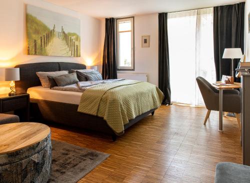 ein Schlafzimmer mit einem Bett, einem Tisch und einem Stuhl in der Unterkunft Appartementhaus am Schloss in Weimar