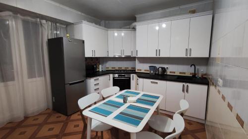 a kitchen with white cabinets and a table and chairs at Запорізька 19 City Rooms in Bila Tserkva