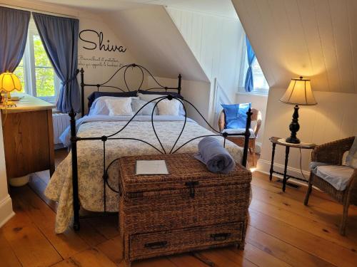 een slaapkamer met een bed met een smeedijzeren frame bij Om Chalet 3 avec spa et accès au fleuve in Saint-Laurent-de-l'ile d'Orleans
