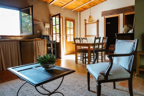 a living room with a table and a chair at LAS GLICINIAS casa rural en el campo in Tordera