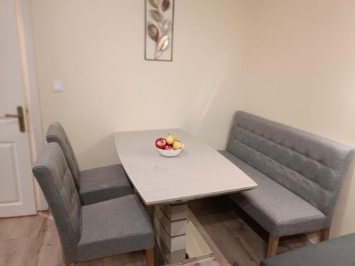 a table with two chairs and a bowl of fruit on it at Apartament Tzar Kaloyan in Burgas