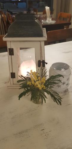 a candle in a lantern on a table with flowers at Hôtel Terminus in Luz-Saint-Sauveur