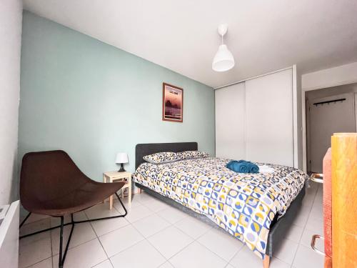 - une chambre avec un lit et une chaise dans l'établissement Le Verrières - Appartement Cozy avec balcon proche de la gare, à Clermont-Ferrand