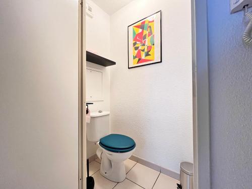 uma casa de banho com WC e assento azul em Le Verrières - Appartement Cozy avec balcon proche de la gare em Clermont-Ferrand