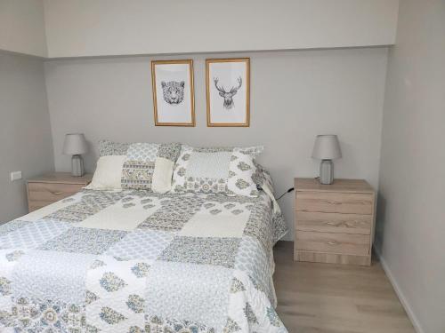 a bedroom with a bed with a blue and white quilt at Hostal Paso por La Serena in La Serena