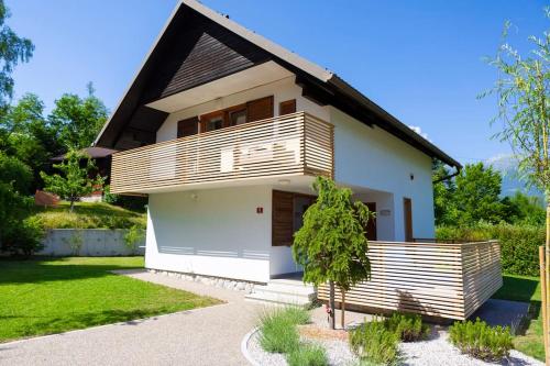 una casa blanca con techo negro en Private green getaway, en Bled