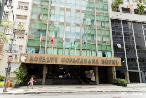 a woman walking in front of a building at Royalty Copacabana Hotel in Rio de Janeiro