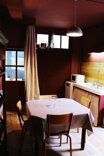 una cocina con mesa y sillas y una cocina con mesa y mesa. en Eau Berges - Chez Mamie, en Vicdessos