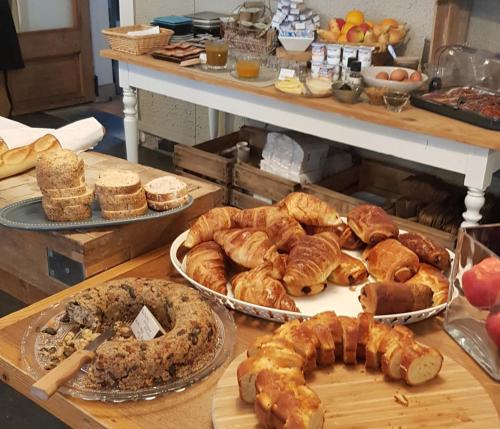 a table with many different types of pastries and pies at Hôtel Terminus in Luz-Saint-Sauveur
