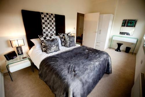 Un dormitorio con una cama grande con almohadas. en Chelmsford Serviced Apartments en Chelmsford