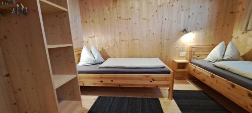 um quarto com 2 camas num quarto de madeira em Chalet Ablon em Saalbach-Hinterglemm
