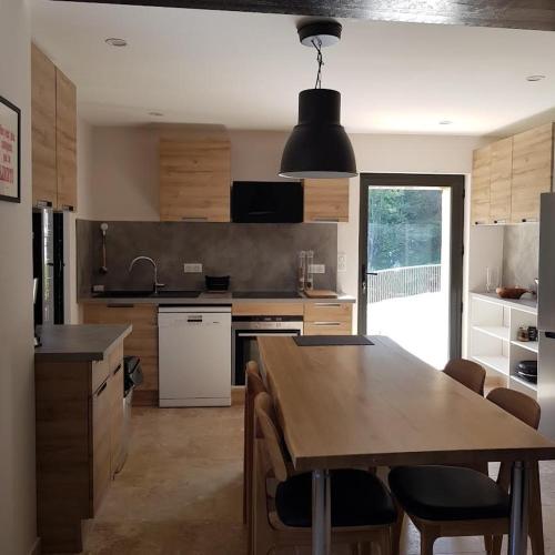 une cuisine avec une table en bois et une salle à manger dans l'établissement Les Tuileries de Lencieux, à Gigondas