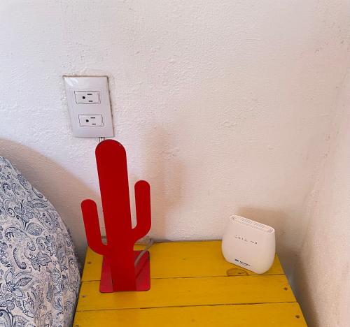 een rode cactus zittend op een tafel naast een socket bij Casa Moka in La Peñita de Jaltemba