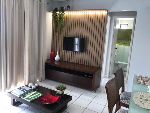 sala de estar con TV y mesa en Apartamento Oceano Atlantico, en Salvador