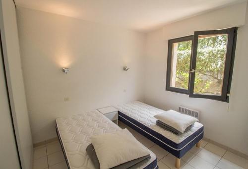 Zimmer mit 2 Betten und einem Fenster in der Unterkunft L'embarcadère in Mimizan-Plage