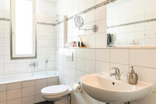 Baño blanco con lavabo y aseo en Appartementhaus am Schloss, en Weimar