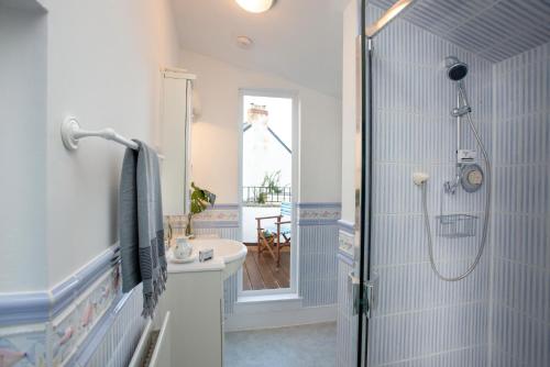 a bathroom with a shower and a sink at Rose Cottage in Sidmouth