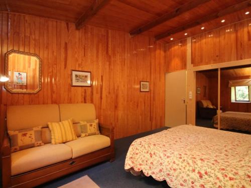 a bedroom with a bed and a couch in it at Appartement Mont-Dore, 3 pièces, 5 personnes - FR-1-608-161 in Le Mont-Dore