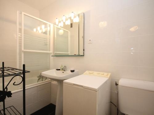 une salle de bain blanche avec un lavabo et un miroir dans l'établissement Mont-Dore: Duplex 3 pièces avec balcon, parking - FR-1-608-161, à Le Mont-Dore