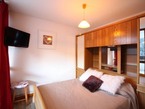 - une chambre avec un lit et une télévision dans l'établissement Mont-Dore: Beau T3 avec terrasse, garage et wifi - FR-1-608-178, à Le Mont-Dore