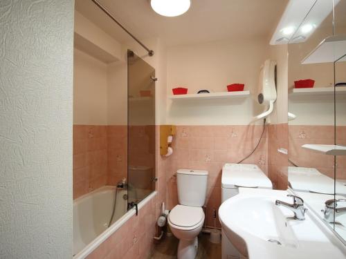 La salle de bains est pourvue de toilettes, d'un lavabo et d'une baignoire. dans l'établissement Mont-Dore: Beau T3 avec terrasse, garage et wifi - FR-1-608-178, à Le Mont-Dore