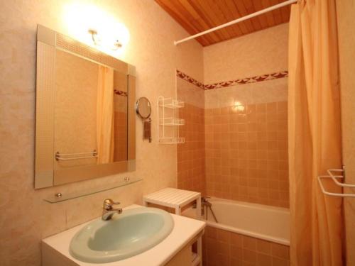 une salle de bain avec un lavabo, un miroir et une baignoire dans l'établissement Beau duplex 3 pièces avec balcon, parking, à 150m du centre du Mont-Dore et 400m des Thermes - FR-1-608-187, à Le Mont-Dore