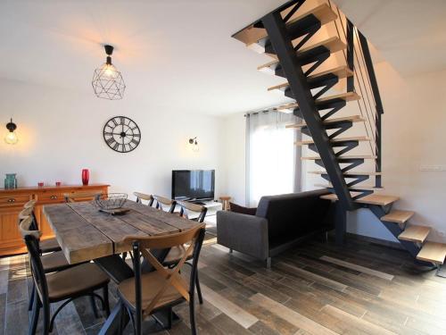 une salle à manger avec une table et un escalier en colimaçon dans l'établissement Maison récente 70m² | 8 pers | 3 chambres | Terrasse | Parking | La Bourboule - FR-1-608-203, à La Bourboule